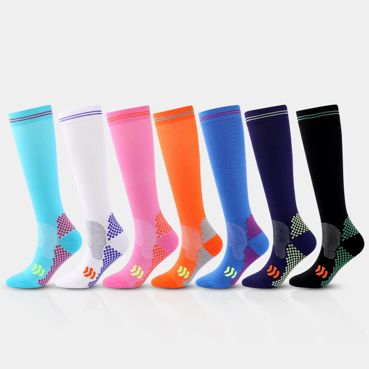 Seven colorful knee-high sport panel compression socks in aqua, white, pink, orange, blue, navy and black